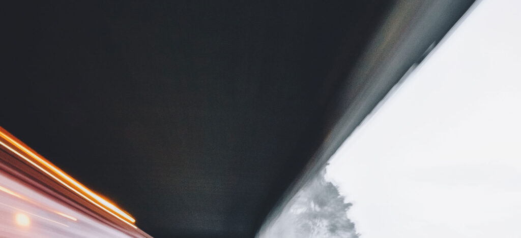 Zdjęcie w ruchu z wnętrza pojazdu, dynamiczny widok drogi o zmierzchu lub w nocy